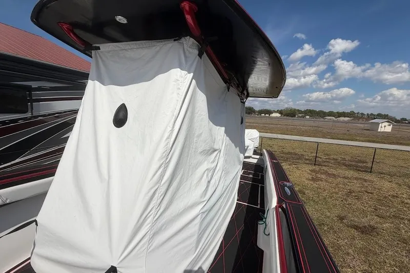  Yacht Photos Pics 2018 Statement 380 Open boat with white cover, parked outdoors under blue sky.