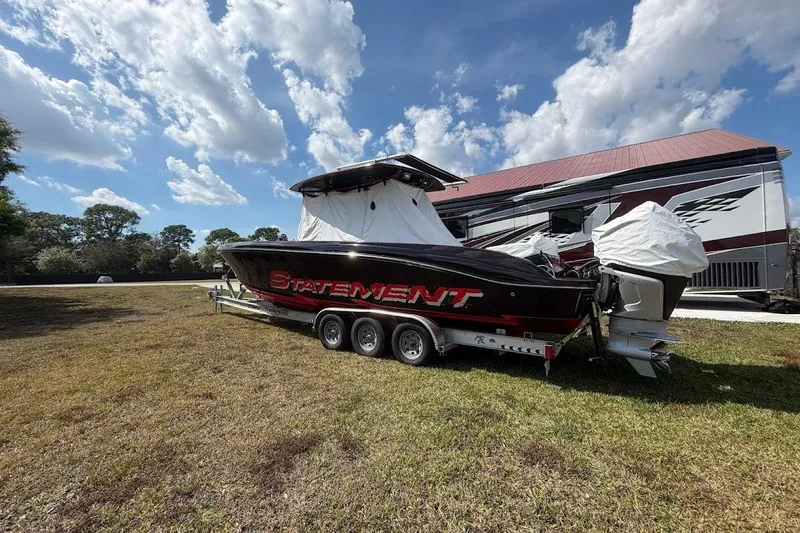  Yacht Photos Pics 2018 Statement 380 Open boat on trailer, parked on grass under a partly cloudy sky.