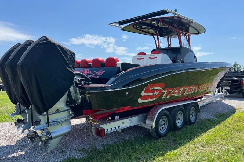 Yacht Photos Pics 2018 Statement 380 Open boat on trailer with triple engines, parked on grass.