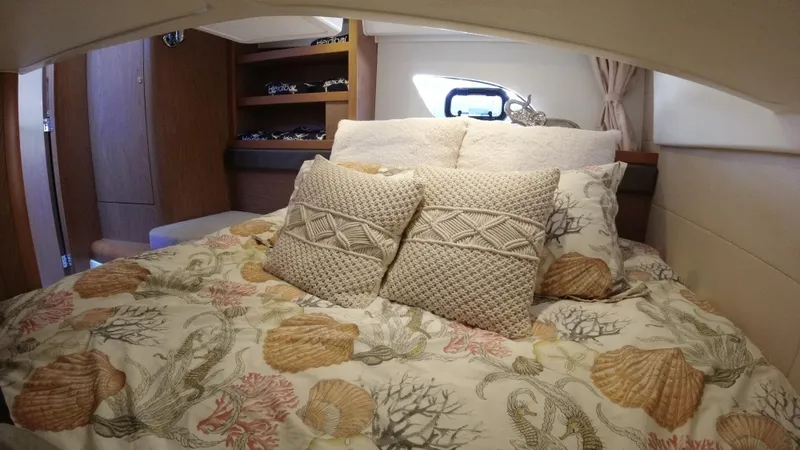 Yacht Photos Pics Cozy bedroom in 2016 Beneteau GT35 yacht with decorative pillows and seashell-themed bedding.