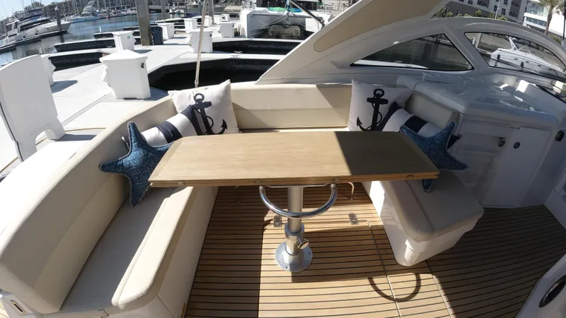  Yacht Photos Pics 2016 Beneteau GT35 yacht interior with cushioned seating and wooden table.