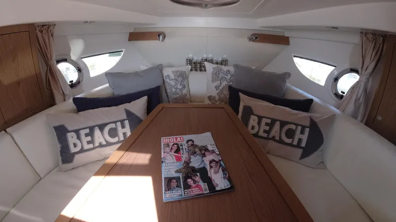  Yacht Photos Pics Interior of 2016 Beneteau GT35 yacht with cozy seating and beach-themed pillows.