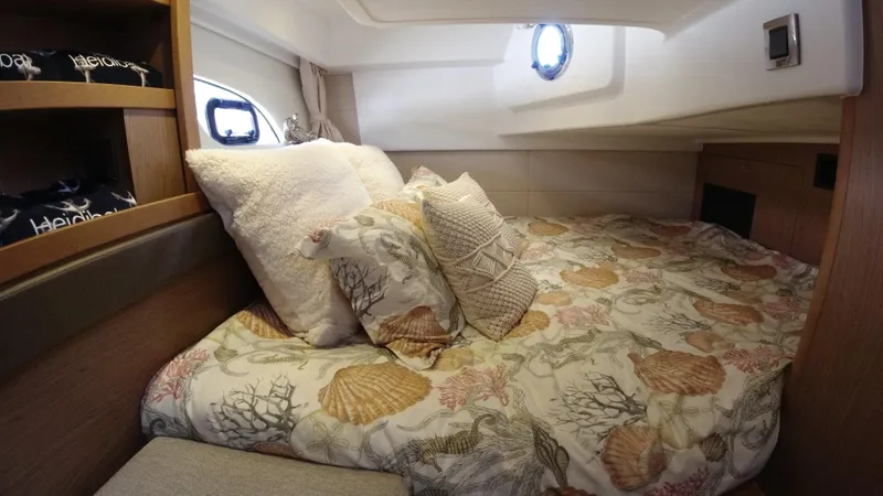  Yacht Photos Pics Cozy bedroom in 2016 Beneteau GT35 yacht with decorative pillows and porthole windows.