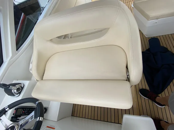  Yacht Photos Pics 2016 Beneteau GT35 helm seat with white upholstery and teak flooring.