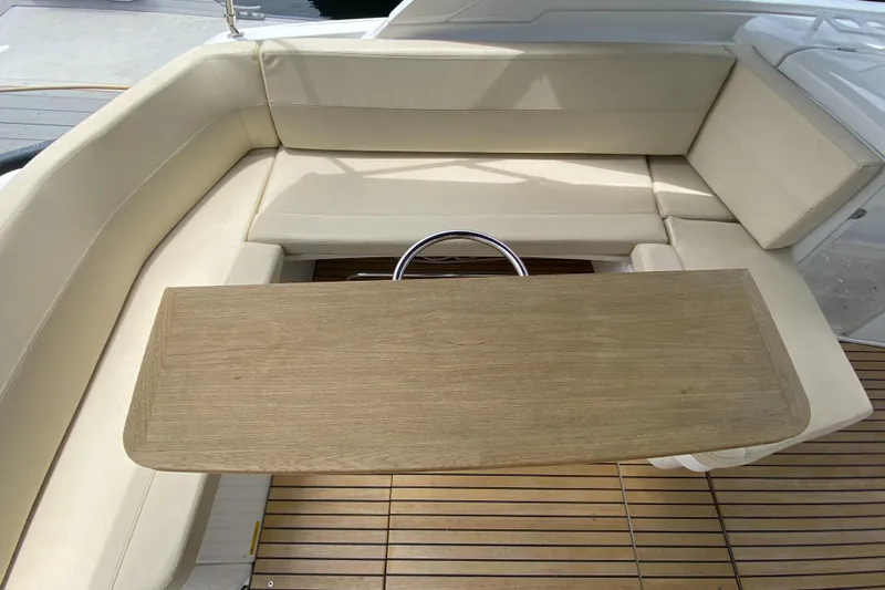  Yacht Photos Pics 2016 Beneteau GT35 yacht interior with beige seating and wooden table.