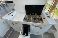 Compact kitchen area on 2023 Quarken 27 T-Top V2 boat with sink and stove.