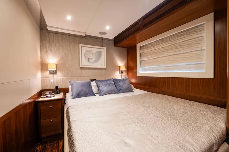 Firefly Yacht Photos Pics Luxurious bedroom interior in 2015 Mulder 94 yacht, featuring elegant wood paneling and cozy lighting.