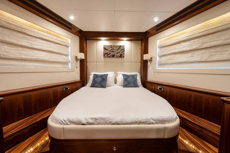 Firefly Yacht Photos Pics Luxurious bedroom interior on 2015 Mulder 94 yacht, featuring elegant wood paneling and cozy bedding.