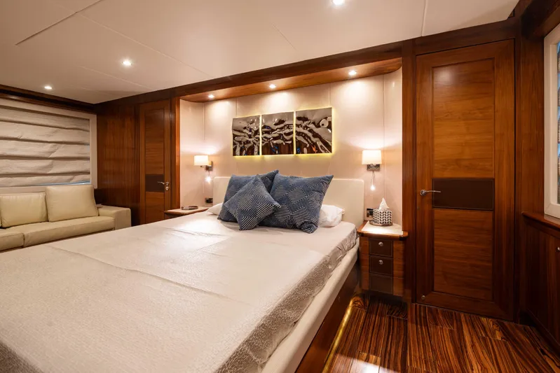 Firefly Yacht Photos Pics Luxurious bedroom interior on a 2015 Mulder 94 yacht, featuring elegant wood finishes.