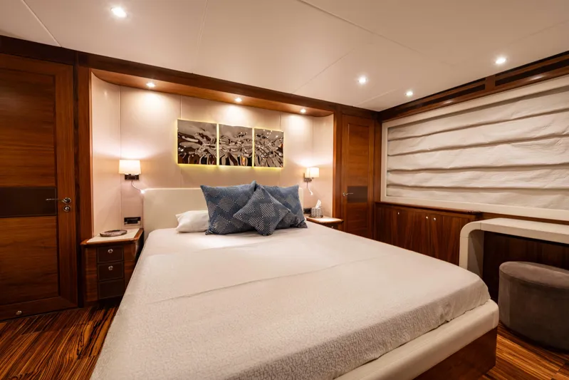 Firefly Yacht Photos Pics Luxurious bedroom interior on a 2015 Mulder 94 yacht, featuring elegant wood finishes.