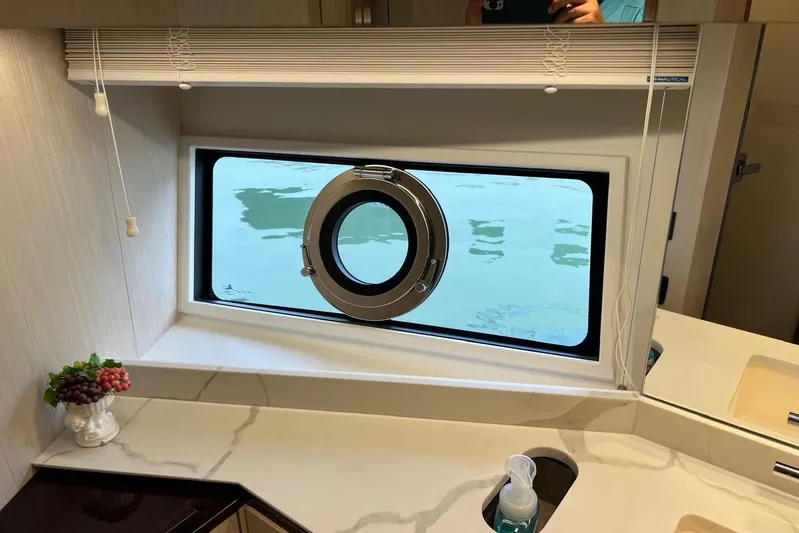  Yacht Photos Pics Luxurious Azimut Grande 25M yacht interior with porthole window, marble countertop, and decorative elements.