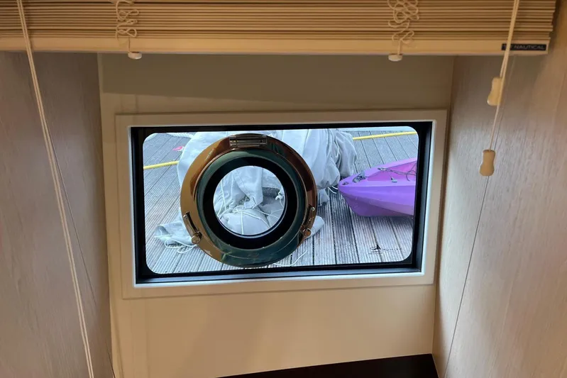  Yacht Photos Pics Porthole view from 2020 Azimut Grande 25M yacht, showing dock and purple kayak.