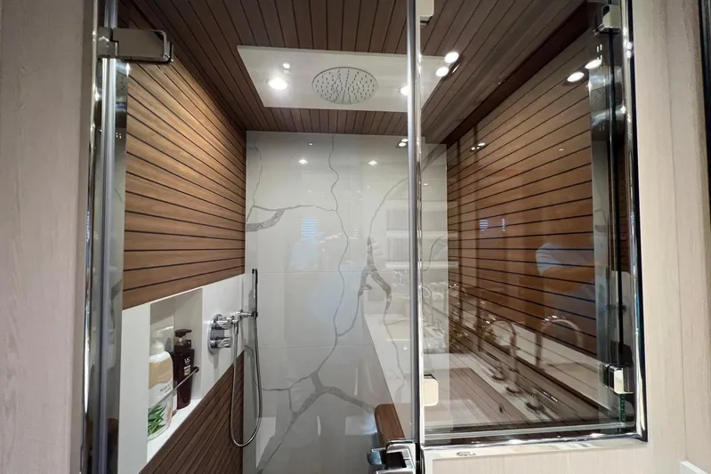  Yacht Photos Pics Luxurious shower in 2020 Azimut Grande 25M yacht with wood paneling and modern fixtures.