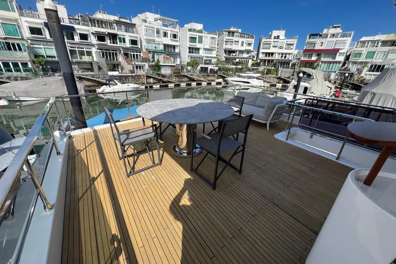  Yacht Photos Pics Azimut Grande 25M 2020 yacht deck with seating, overlooking marina and waterfront buildings.