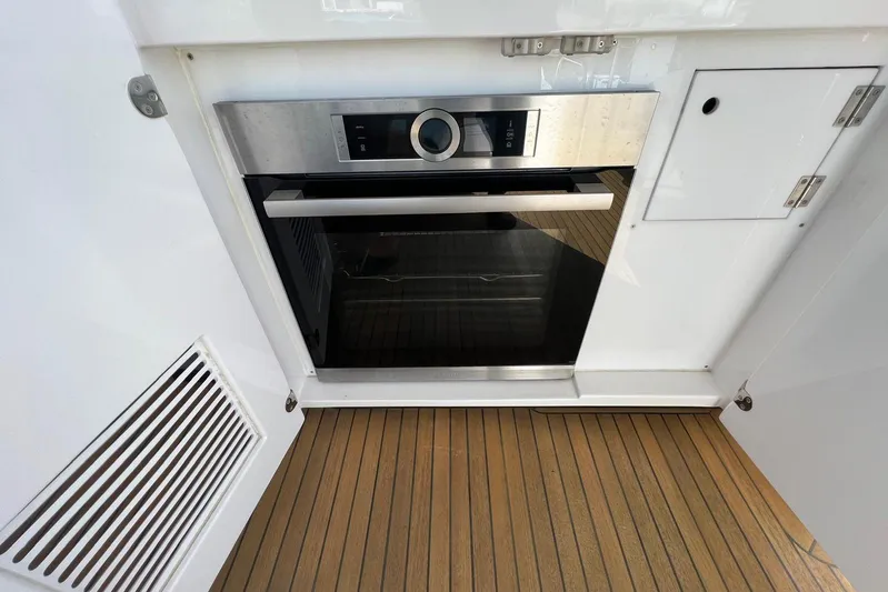  Yacht Photos Pics Modern oven on Azimut Grande 25M yacht, 2020 model, with sleek design and wooden flooring.