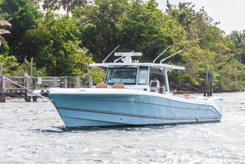 Relentless Yacht Photos Pics 2021 HCB 53 Sueños boat cruising near lush greenery.