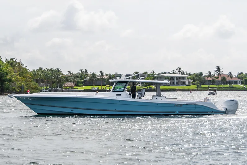 Relentless Yacht Photos Pics 2021 HCB 53 Sueños boat cruising on a sunny day near waterfront homes.