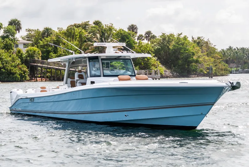 Relentless Yacht Photos Pics 2021 HCB 53 Sueños boat on water, surrounded by lush greenery.