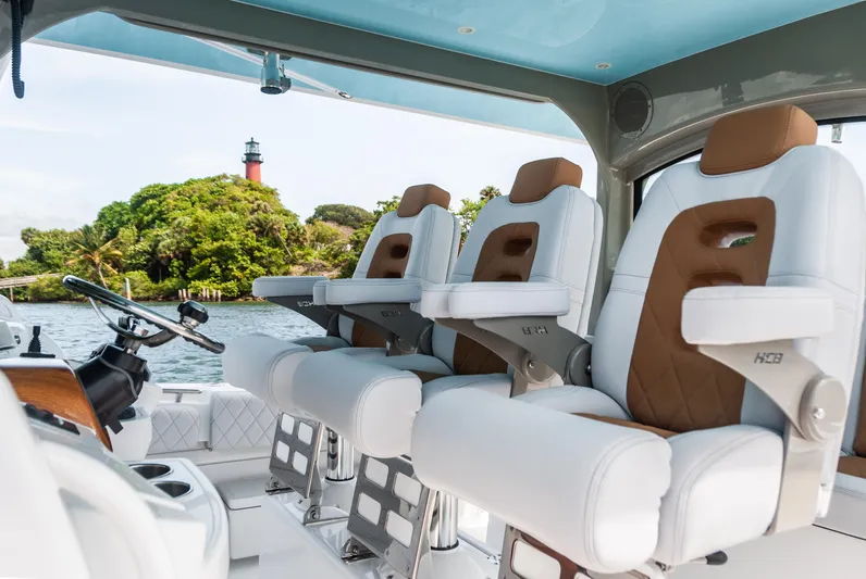 Relentless Yacht Photos Pics Interior of 2021 HCB 53 Sueños boat with luxury seating and scenic lighthouse view.