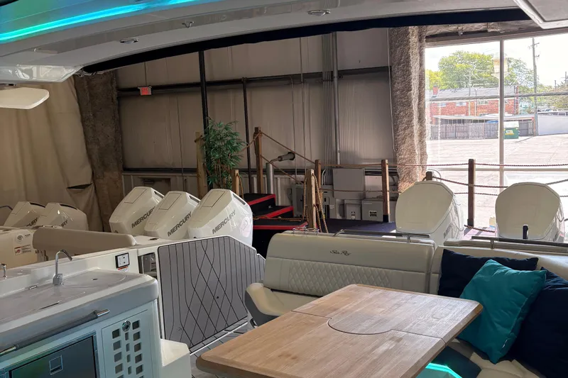  Yacht Photos Pics 2025 Searay 400 SLX boat interior with seating, table, and Mercury engines in a showroom.