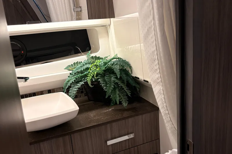  Yacht Photos Pics Luxurious bathroom in 2025 Searay 400 SLX with modern sink and decorative plant.