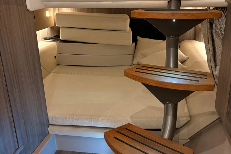  Yacht Photos Pics Interior cabin of 2025 Searay 400 SLX with modern wooden steps and cozy bedding.