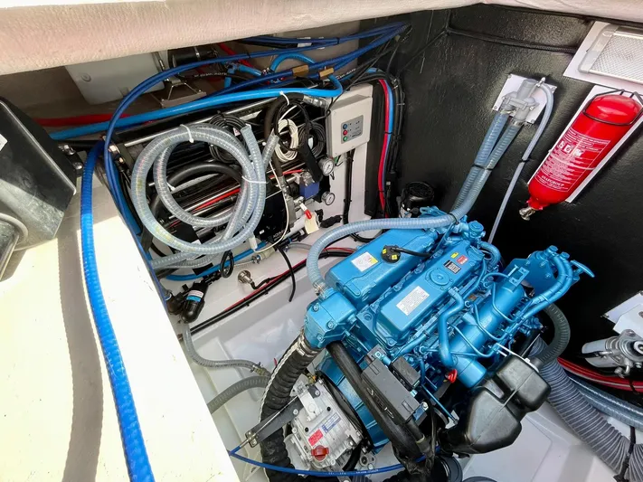 Bali 4.2 Yacht Photos Pics Engine compartment of a 2026 Bali 4.2 boat, featuring a blue engine and fire extinguisher.