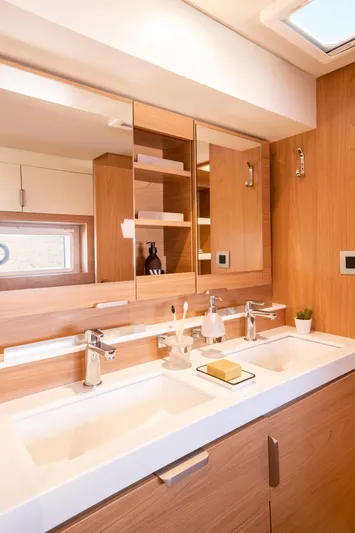 Bali 4.2 Yacht Photos Pics Modern bathroom in 2026 Bali 4.2 yacht with dual sinks and wooden cabinetry.