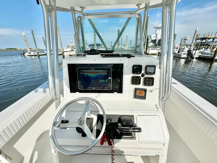  Yacht Photos Pics 2006 Regulator 32 FS boat console with steering wheel and navigation equipment at marina.
