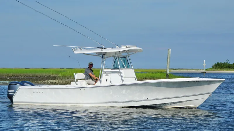  Yacht Photos Pics 2006 Regulator 32 FS boat on calm water, with a person at the helm.