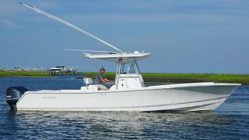  Yacht Photos Pics 2006 Regulator 32 FS boat on calm water with a person at the helm.