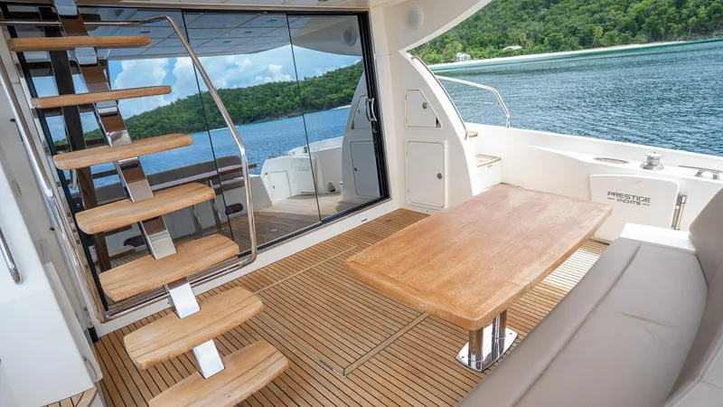  Yacht Photos Pics Luxurious 2013 Prestige 620 yacht interior with wooden deck, table, and scenic ocean view.