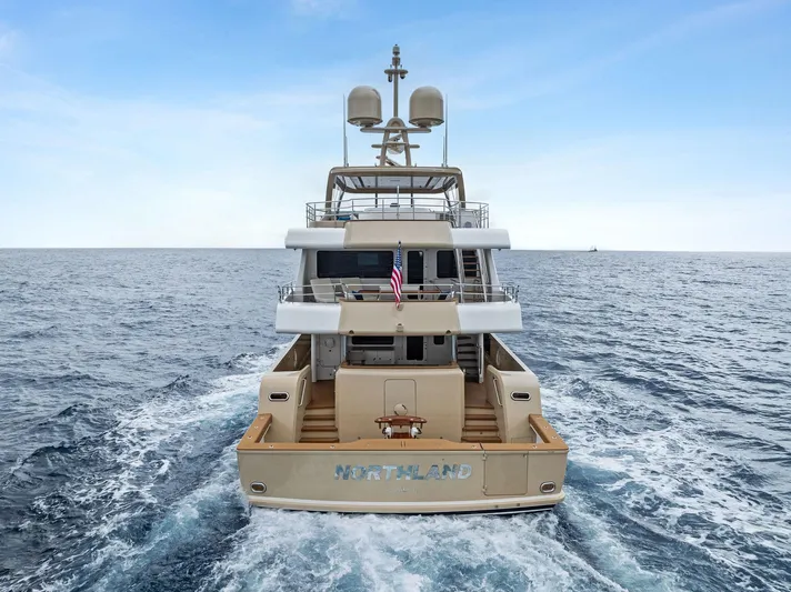 Northland Yacht Photos Pics 2017 Burger 104 Motor Yacht cruising on open sea, rear view.