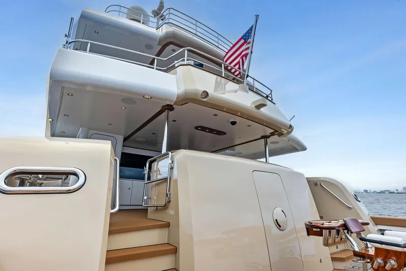 Northland Yacht Photos Pics Luxurious 2017 Burger 104 Motor Yacht with American flag, docked on calm waters.