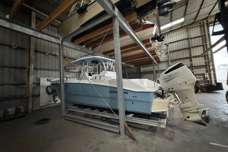  Yacht Photos Pics 2021 Twin Vee 280 CC GF boat with Suzuki engine in storage facility.