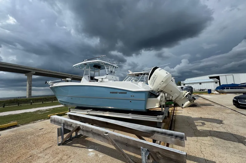  Yacht Photos Pics 2021 Twin Vee 280 CC GF boat on trailer under stormy skies near a bridge.