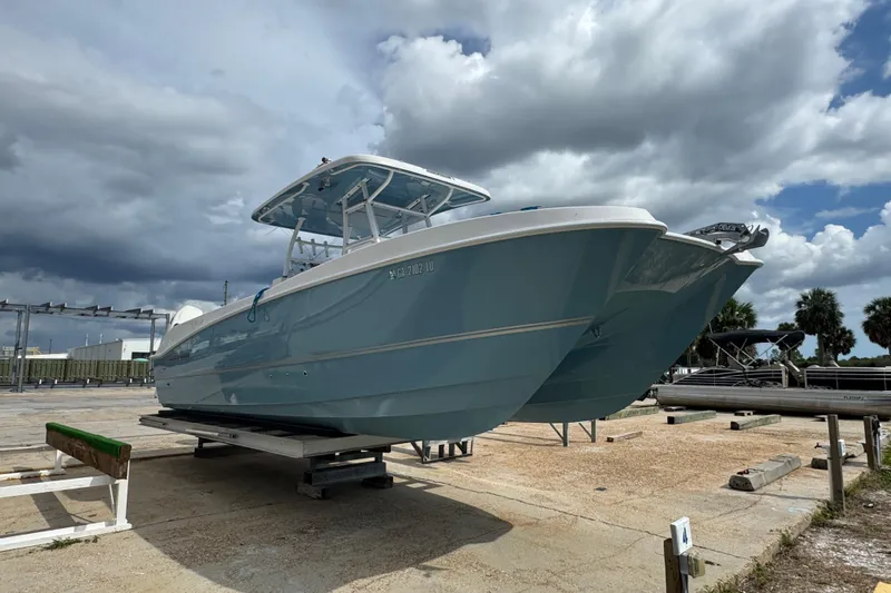  Yacht Photos Pics 2021 Twin Vee 280 CC GF boat on dry dock under cloudy sky.