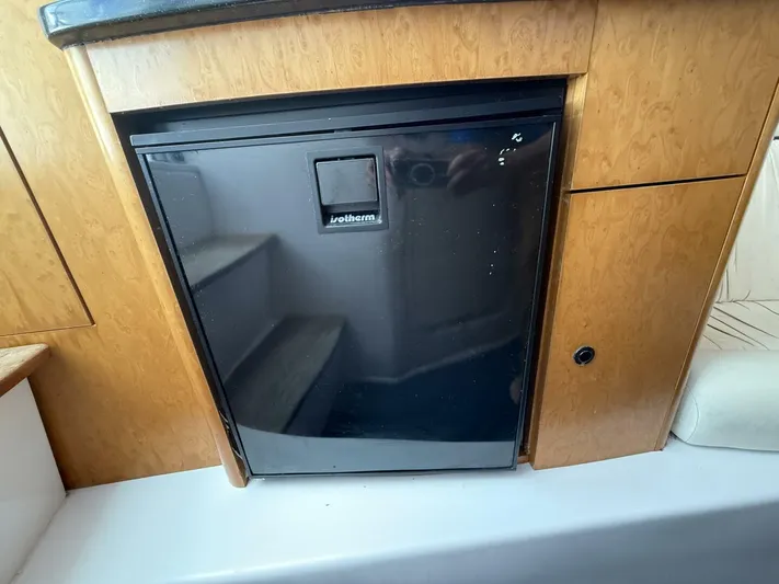  Yacht Photos Pics Compact fridge in 2007 Donzi 38 ZSF boat interior, surrounded by wooden cabinetry.
