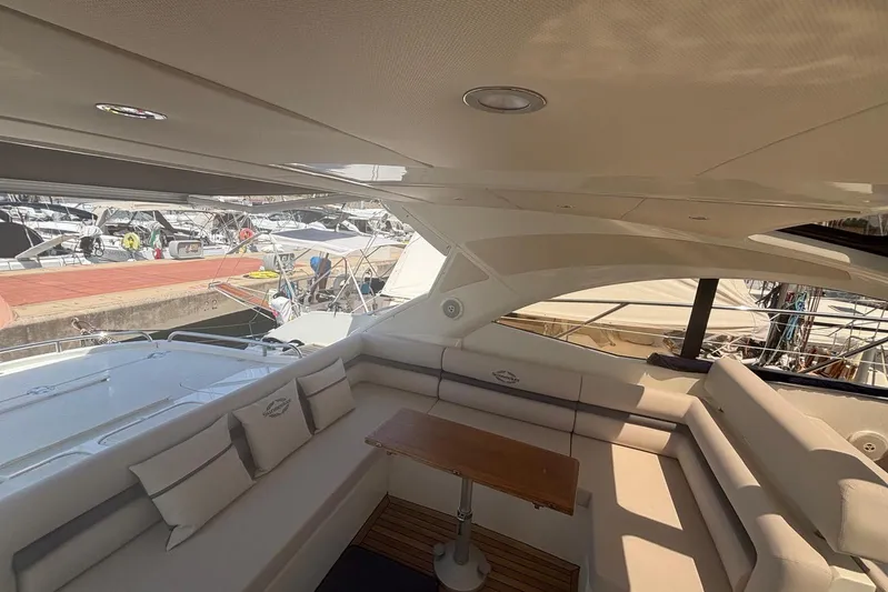  Yacht Photos Pics Luxurious interior of 2010 Sunseeker Portofino 48 yacht with plush seating and wooden table.