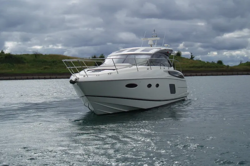 Off Season Yacht Photos Pics 2015 Princess V48 yacht cruising on a calm waterway under cloudy skies.