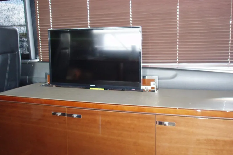 Off Season Yacht Photos Pics Interior of 2015 Princess V48 yacht with TV and wooden cabinetry.