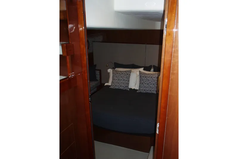 Off Season Yacht Photos Pics Luxurious cabin interior of 2015 Princess V48 yacht with elegant bedding and wooden finishes.