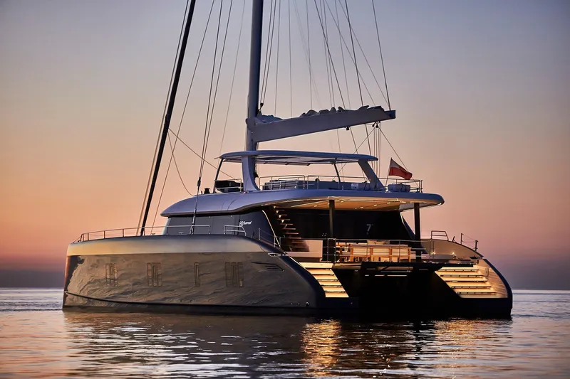  Yacht Photos Pics Luxurious 2026 Sunreef 80 yacht at sunset, featuring elegant design and illuminated deck.