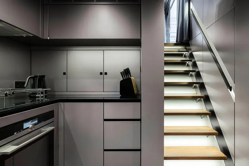  Yacht Photos Pics Modern kitchen and staircase in 2026 Sunreef 80 yacht, featuring sleek cabinetry and contemporary design.