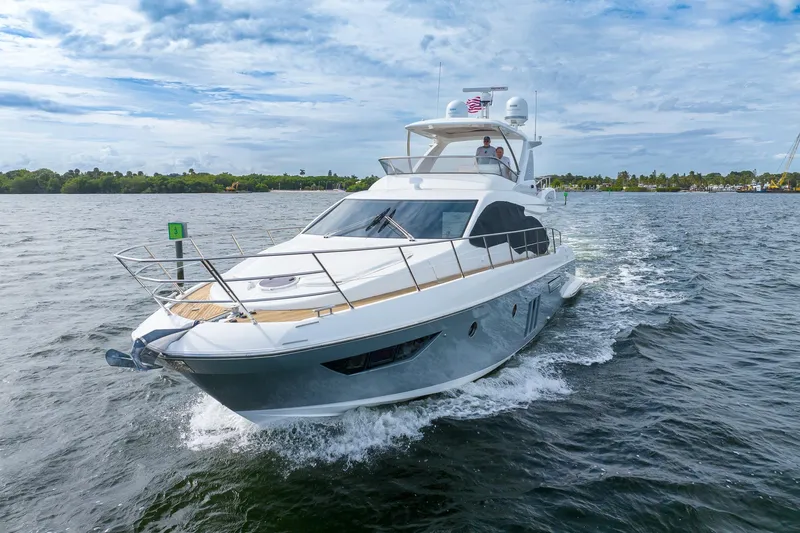 “just Chillin” Yacht Photos Pics 2014 Azimut 54 Flybridge yacht cruising on a scenic waterway under a partly cloudy sky.
