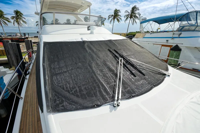 “just Chillin” Yacht Photos Pics 2014 Azimut 54 Flybridge yacht with covered windshield, docked near palm trees.
