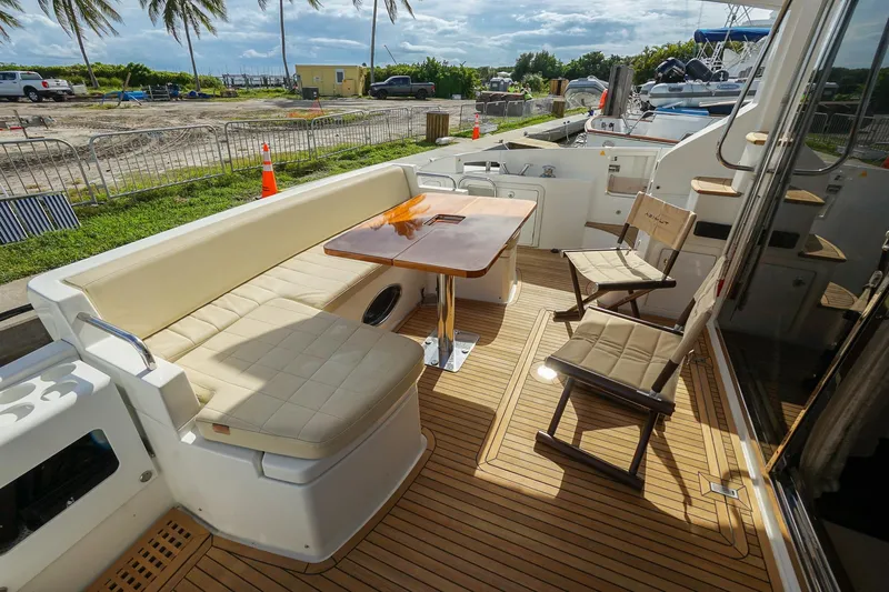 “just Chillin” Yacht Photos Pics Luxurious 2014 Azimut 54 Flybridge yacht deck with seating and table, docked near palm trees.