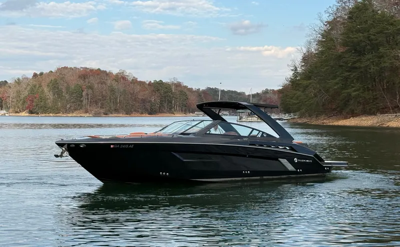  Yacht Photos Pics 2022 Cruisers Yachts 338 CX SB on a serene lake with forested shoreline.