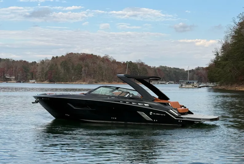  Yacht Photos Pics 2022 Cruisers Yachts 338 CX SB on a serene lake with wooded shoreline.