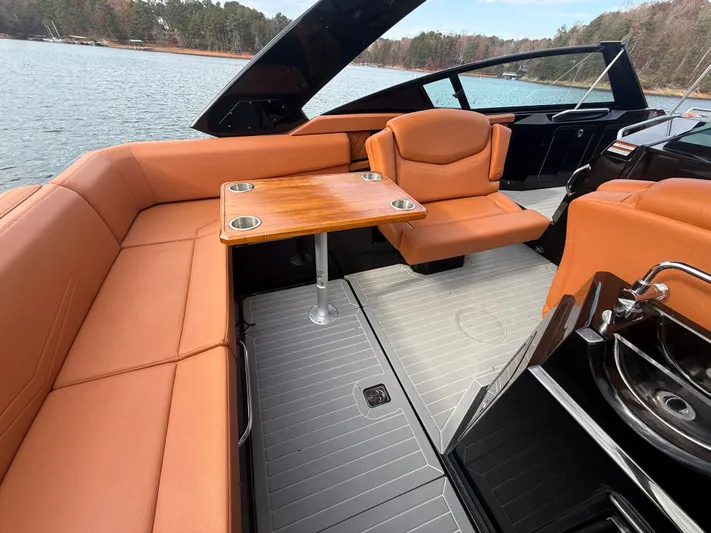  Yacht Photos Pics 2022 Cruisers Yachts 338 CX SB interior with orange seating and wooden table on a lake.